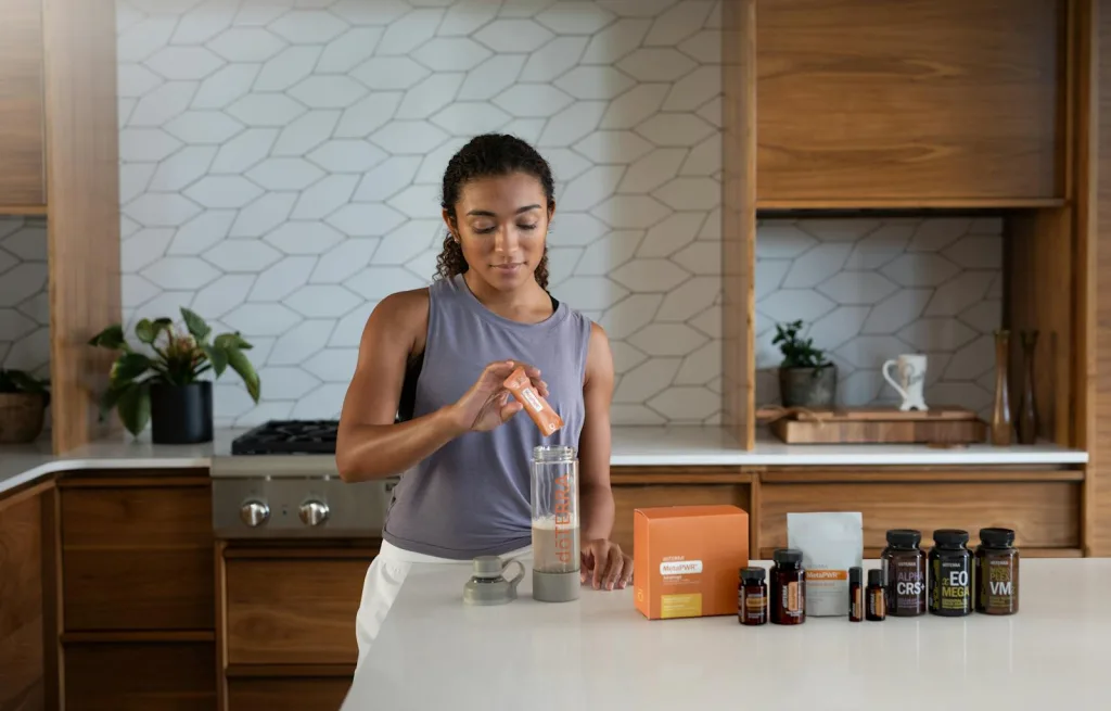 A woman in a kitchen making a drink