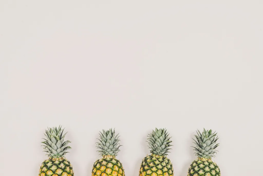 four pineapples on white background