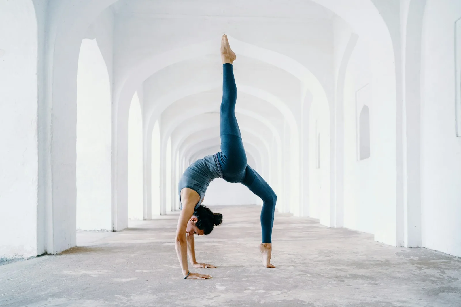 woman in blue leggings and black tank top doing yoga